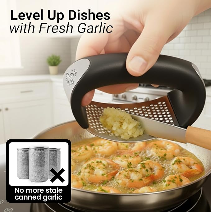 Stainless steel garlic crusher by Tarjah Mart, showing the textured crushing chamber and ergonomic handle for kitchen use.