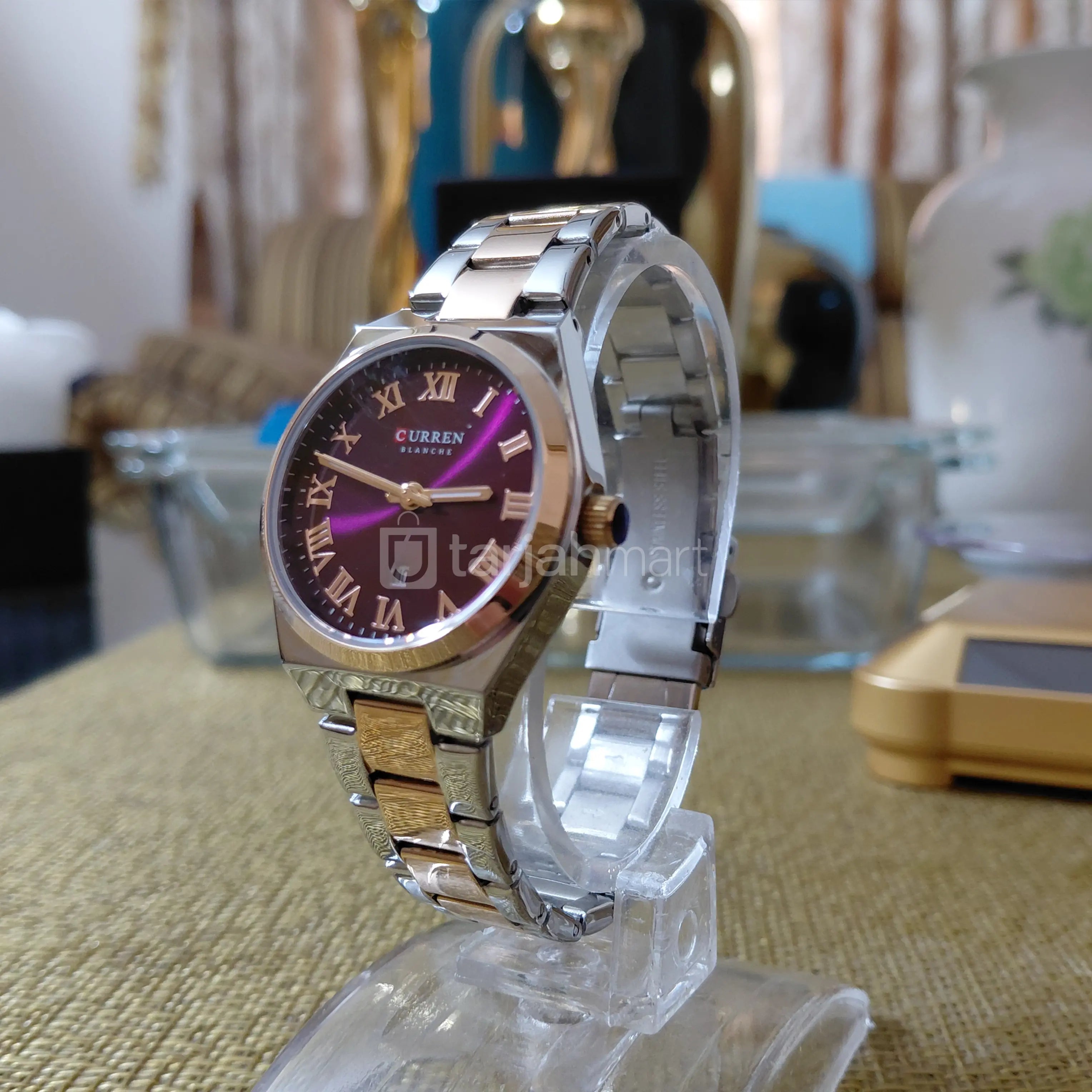 Women's Curren 9095 stainless steel watch with a maroon dial and silver band, showcasing an elegant and modern design.