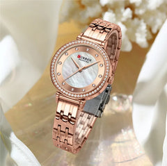 Stainless steel women's watch from Curren 9087 with a sleek silver band and round dial, displayed on a white background.