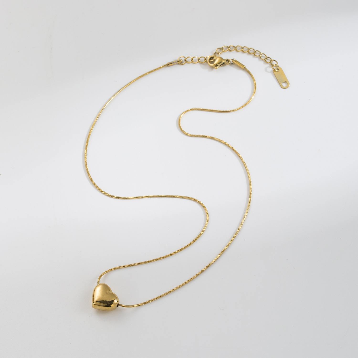 Shiny stainless steel face love necklace from Tarjah Mart with a sleek, polished design and a heart-shaped pendant.