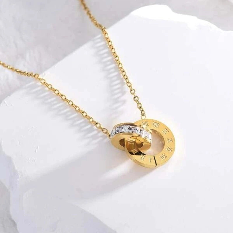 Gold Roman double ring necklace from Tarjah Mart featuring layered circular pendant design on a delicate chain.