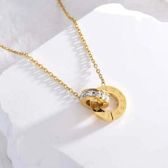 Gold Roman double ring necklace from Tarjah Mart featuring layered circular pendant design on a delicate chain.